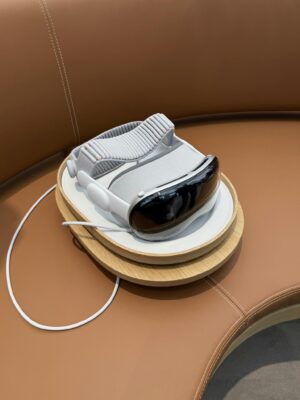 A sleek virtual reality headset rests on a charging stand with elegant leather seating.